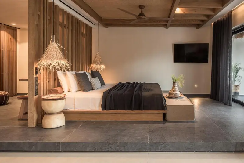 Une chambre spacieuse avec un grand lit et une décoration naturelle.