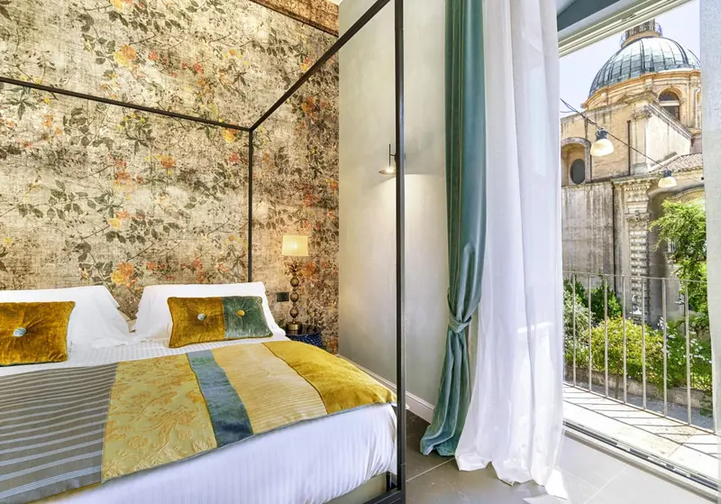 Une chambre avec un lit à baldaquin donnant sur une vue urbaine.