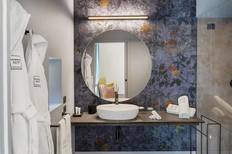 Une salle de bain moderne avec un grand miroir rond au-dessus d'un vasque.