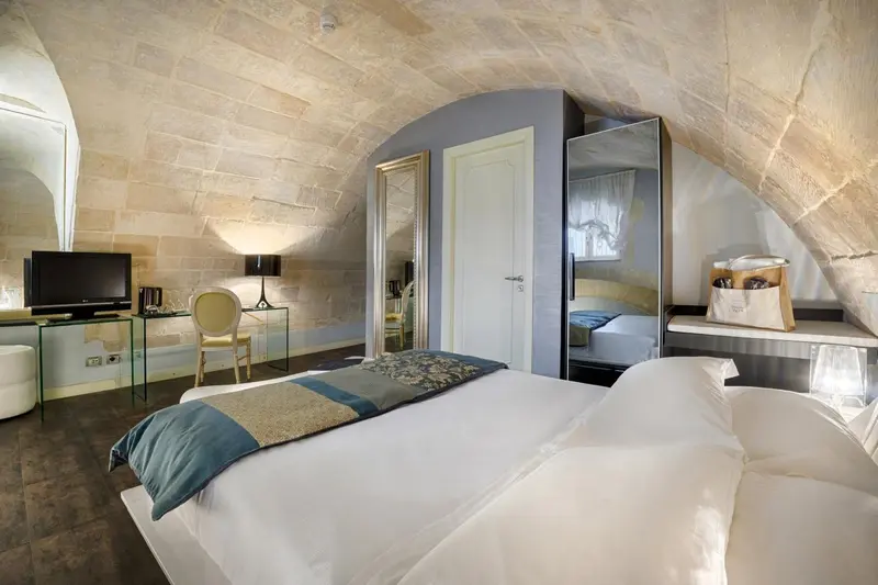 Une chambre à coucher lumineuse avec un lit recouvert d'une courtepointe bleue et grise.