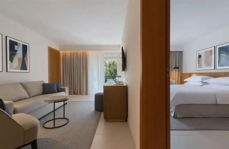 Espace de vie lumineux avec canapé et accès à une chambre.