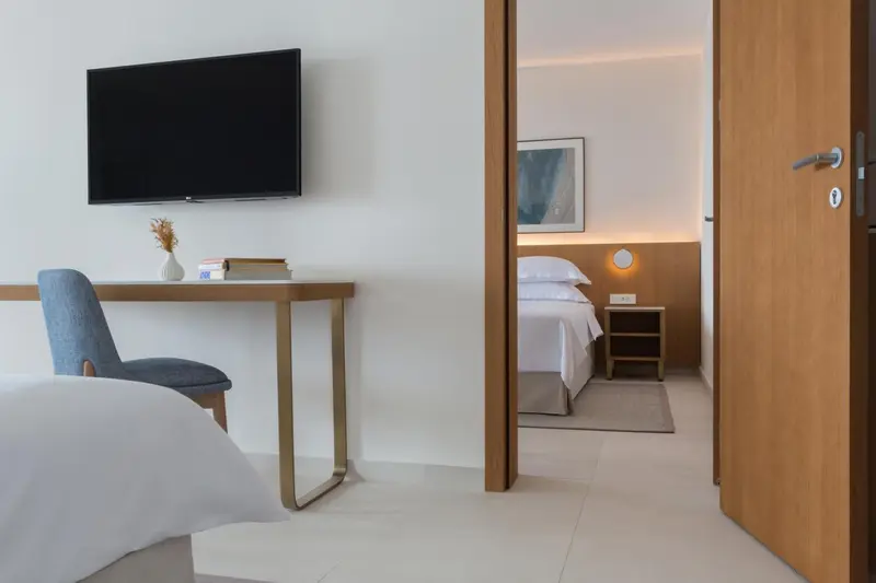 Une chambre lumineuse avec un bureau et un lit fait.