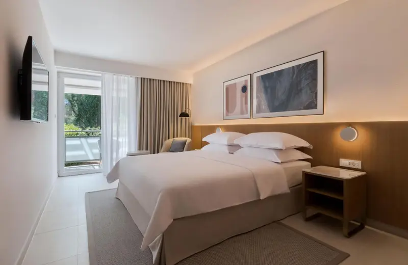 Une chambre lumineuse avec un grand lit et un accès à une terrasse.