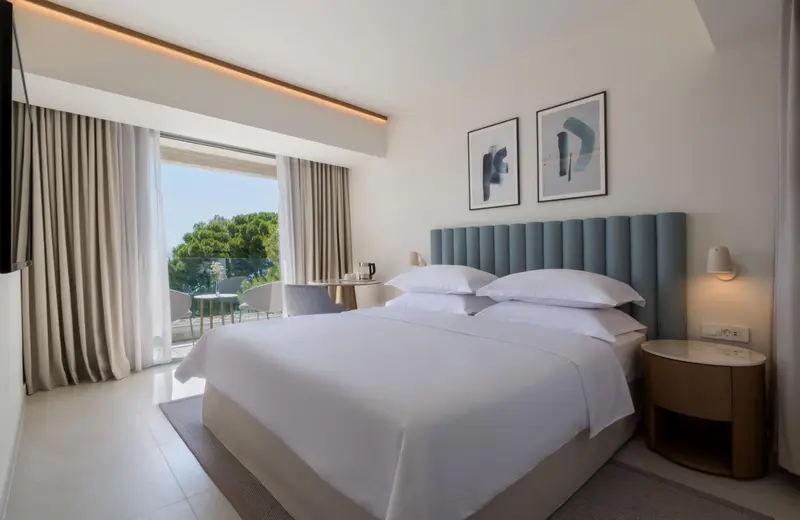 Une chambre lumineuse avec un grand lit et un accès à une terrasse.