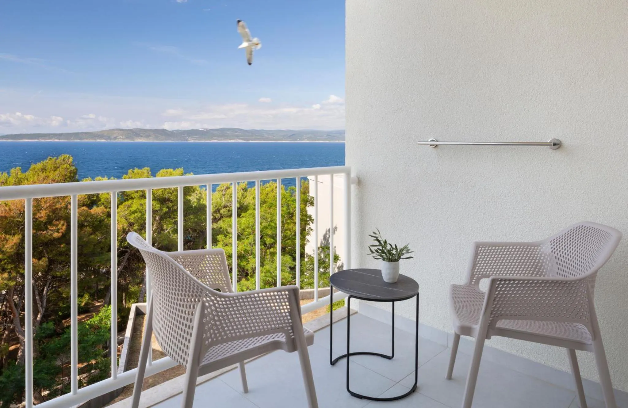 Terrasse avec mobilier d'extérieur et vue sur la mer.