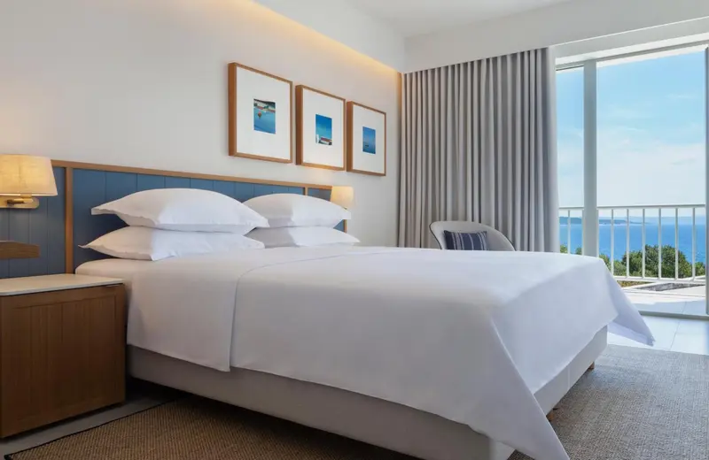 Une chambre lumineuse avec un grand lit et une vue sur la mer.