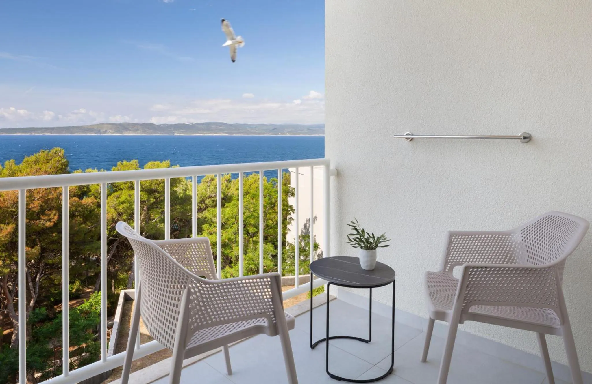 Terrasse avec mobilier d'extérieur et vue sur la mer.
