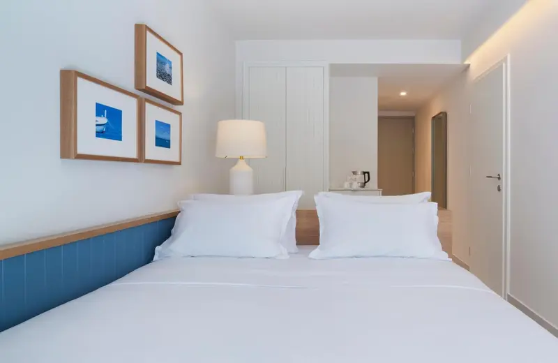 Une chambre lumineuse avec un grand lit recouvert de draps blancs.