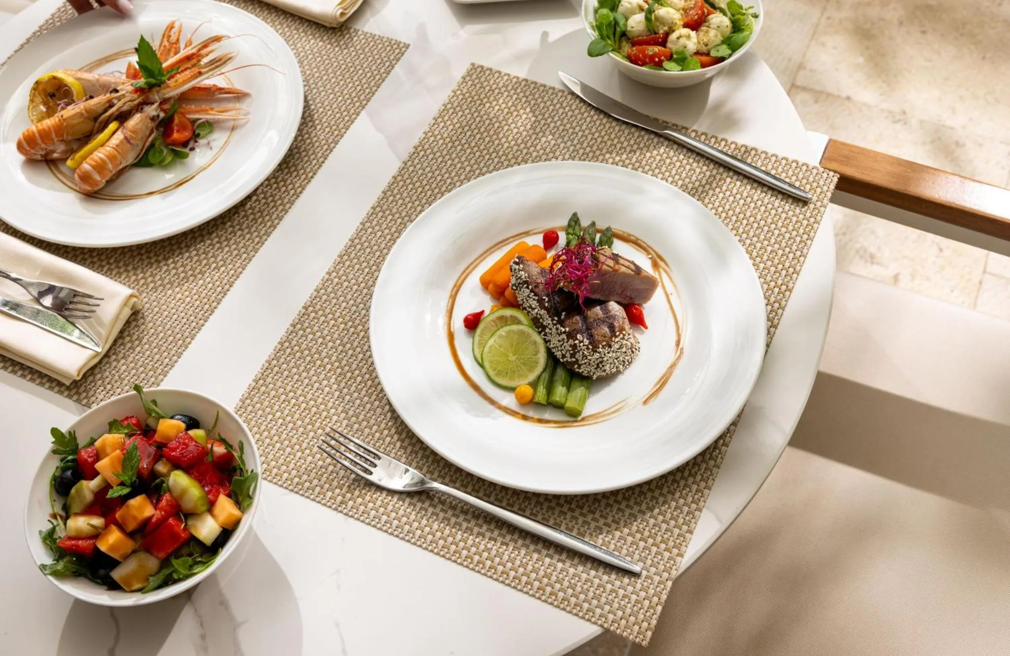 Assiettes de salades et de plats de poisson présentés sur une table.
