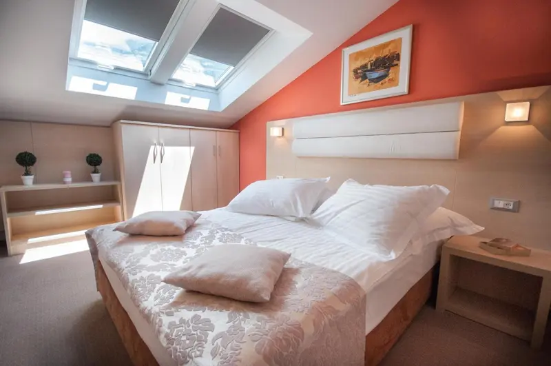 Une chambre lumineuse avec un grand lit et des fenêtres de toit.