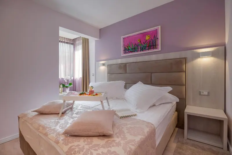 Une chambre lumineuse avec un grand lit et un plateau de petit-déjeuner.