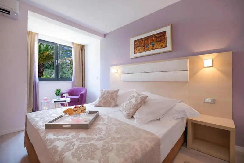 Une chambre lumineuse avec un lit fait et un plateau de petit-déjeuner.