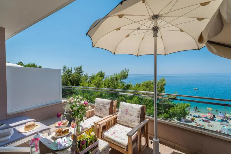 Terrasse aménagée avec mobilier de jardin et vue sur la mer.