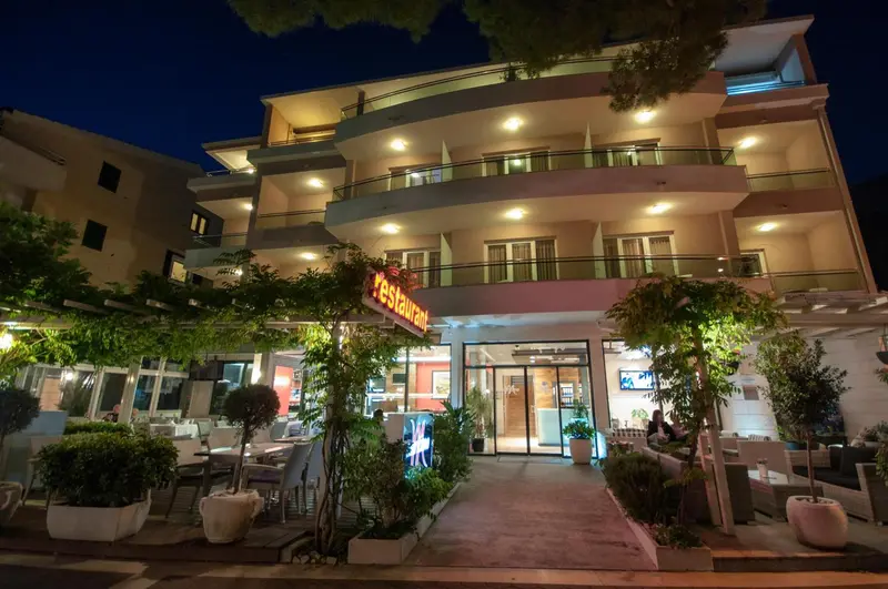 Façade d'un bâtiment éclairé avec un restaurant en rez-de-chaussée.