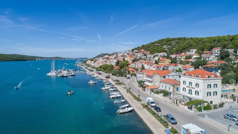 Vue aérienne d'une côte avec des bâtiments et des bateaux amarrés dans un port.