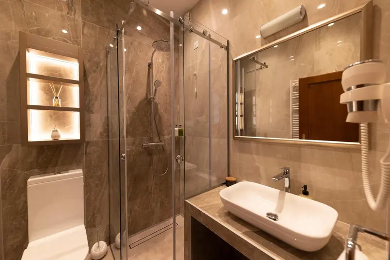 Une salle de bain moderne avec douche à l'italienne et vasque intégrée.