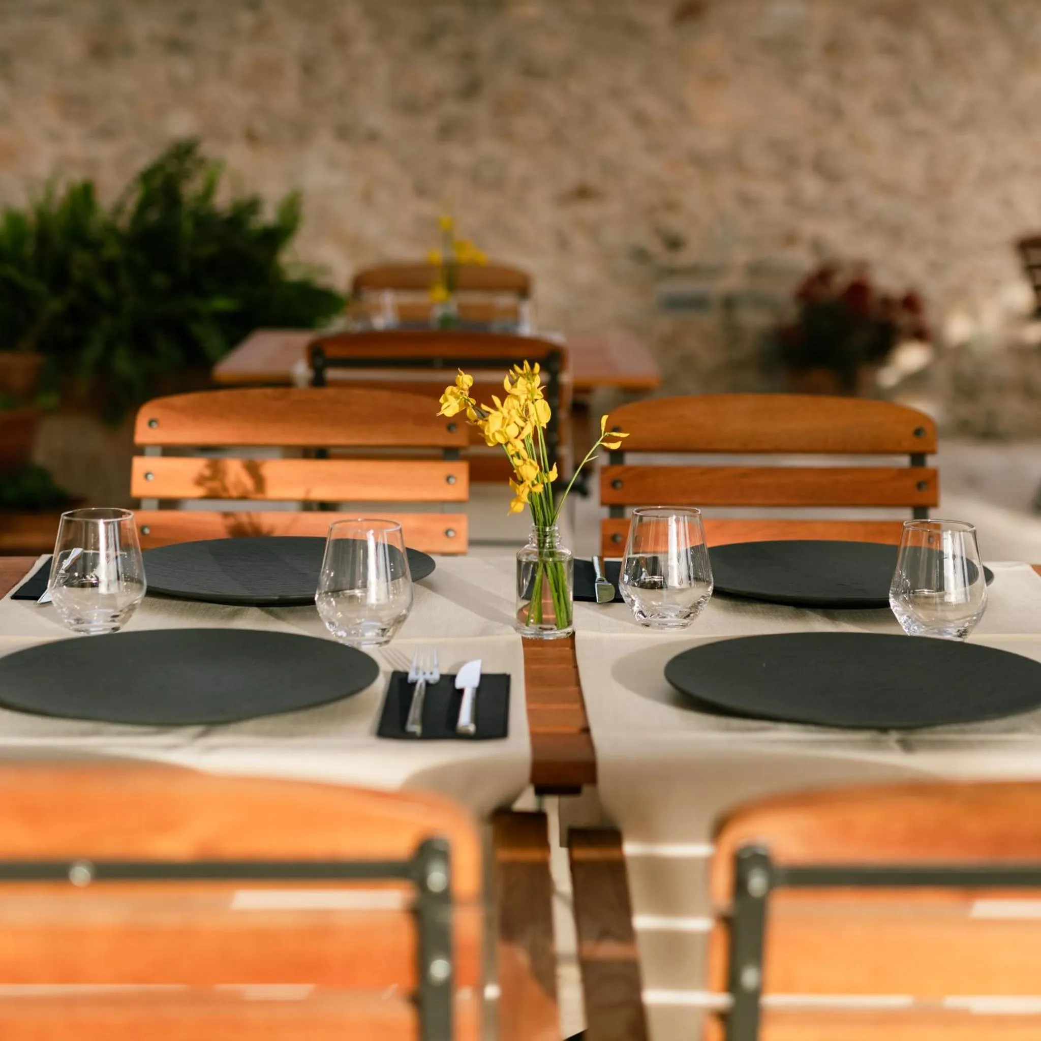 Tables dressées en extérieur avec des verres et des couverts.