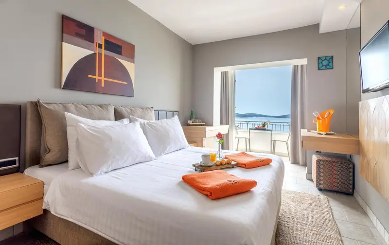 Une chambre lumineuse avec un grand lit et une vue sur la mer.