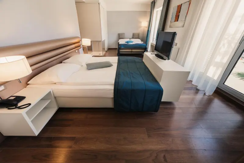 Une chambre lumineuse avec un grand lit et une télévision à écran plat.
