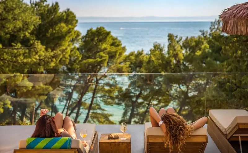 Deux personnes se détendent sur des transats avec vue sur la mer.