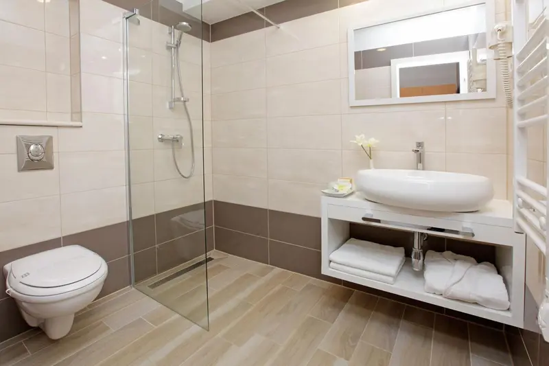 Une salle de bain moderne avec douche à l'italienne et vasque sur meuble.
