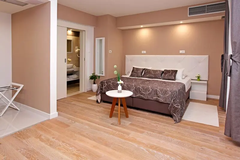 Une chambre lumineuse avec un grand lit et un accès à une salle de bain.