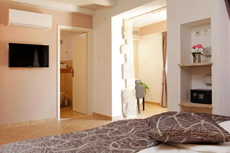Une chambre lumineuse avec un lit recouvert d'une courtepointe décorative.