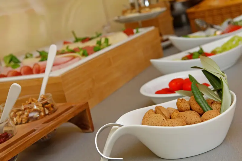 Présentation de charcuterie, de fromages, de fruits et de viennoiseries sur un buffet.