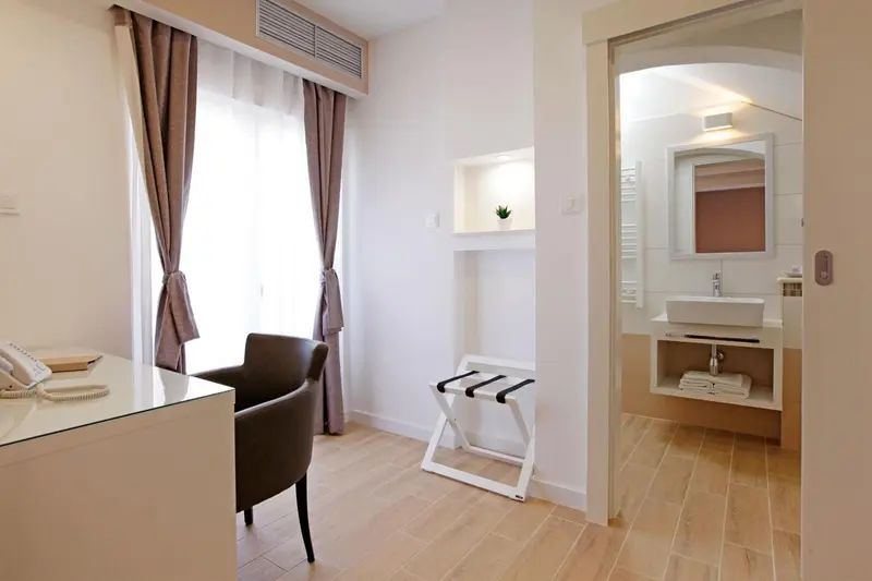 Une chambre lumineuse avec un bureau et un accès à une salle de bain.