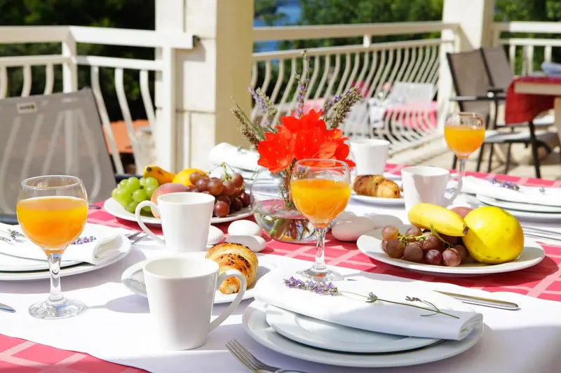 Une table est dressée avec un copieux petit-déjeuner ensoleillé.