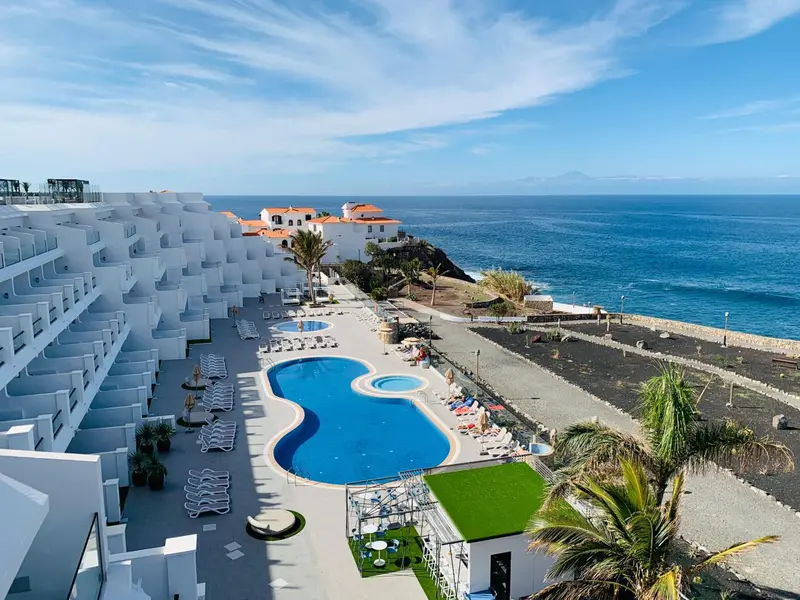 Vue aérienne d'un complexe hôtelier avec piscine et accès à la mer.