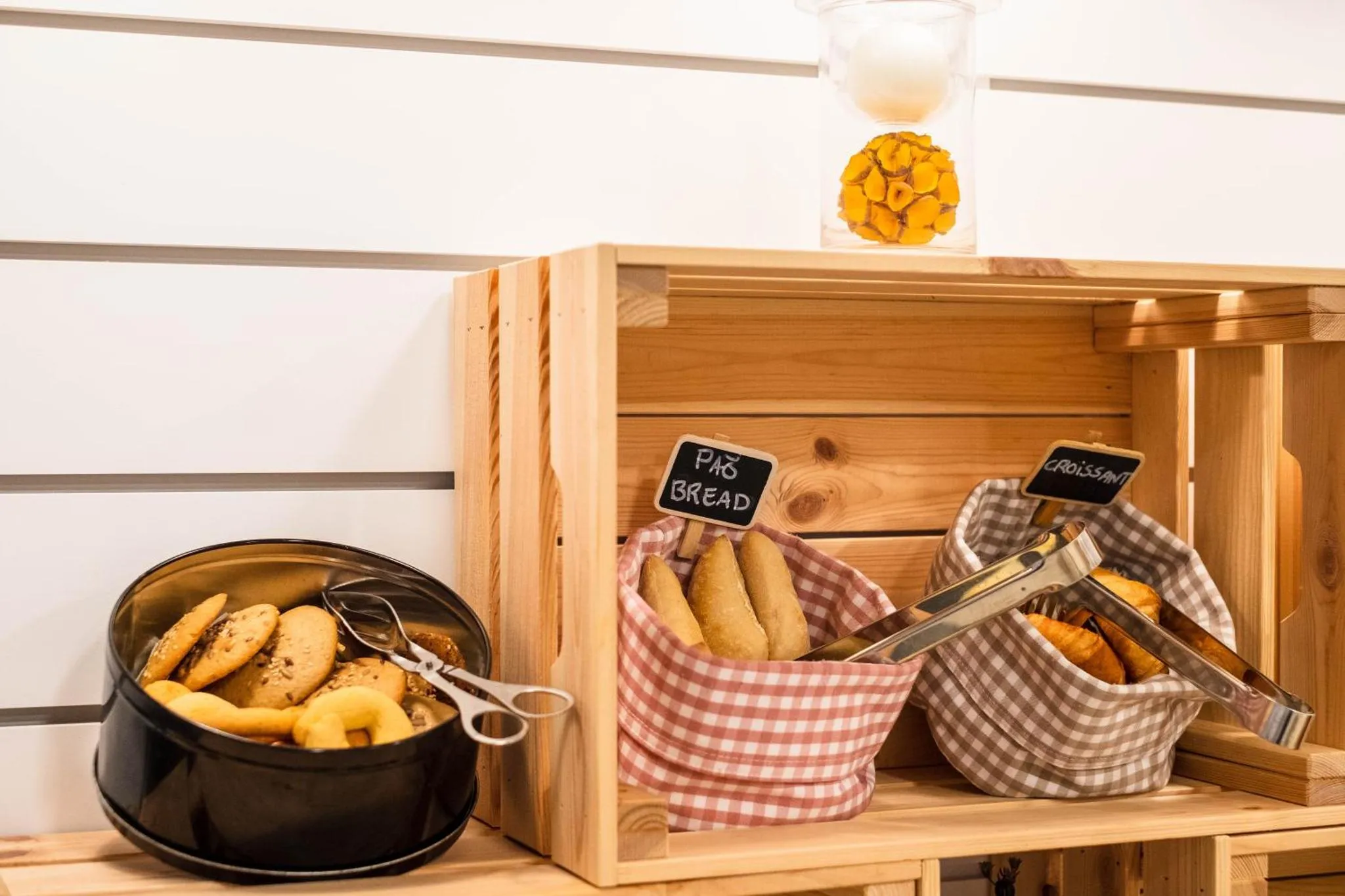 Présentation de viennoiseries et de pain sur un buffet en bois.