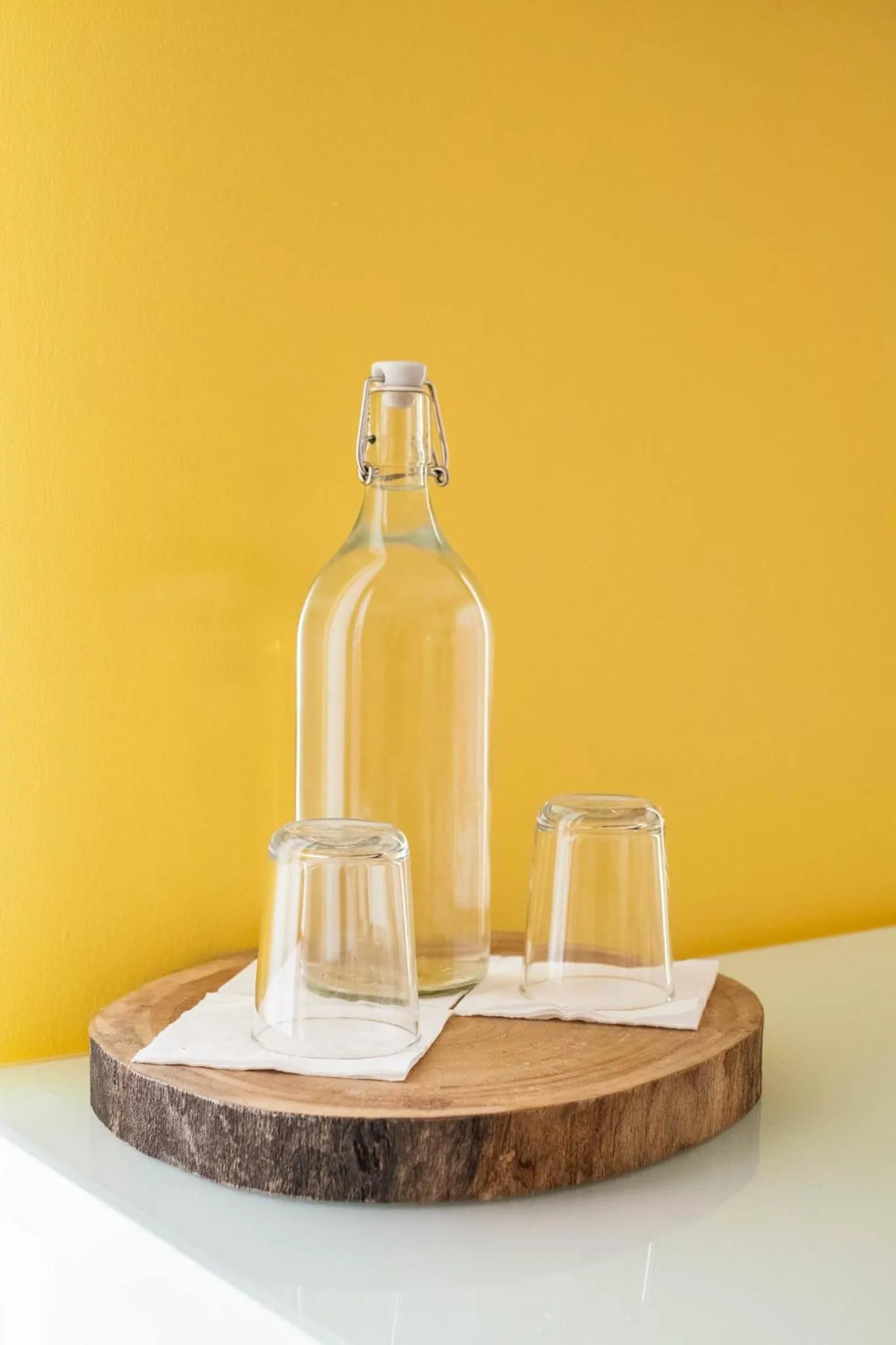 Une bouteille et deux verres sur une planche en bois.