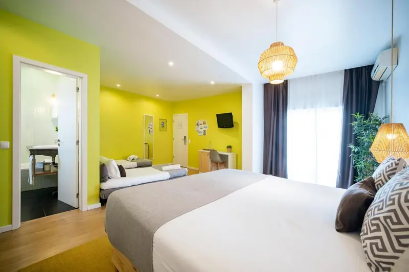 Chambre lumineuse avec un lit double et un espace détente.