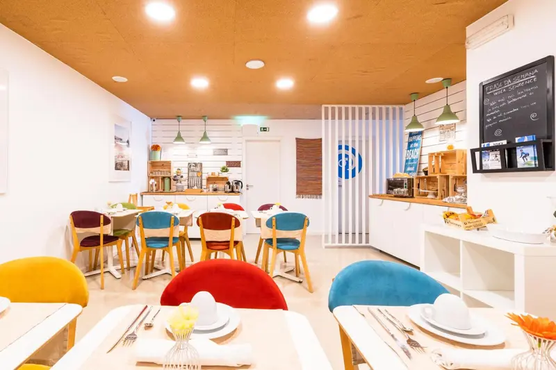 Une salle lumineuse avec des tables et des chaises colorées est prête pour le service.