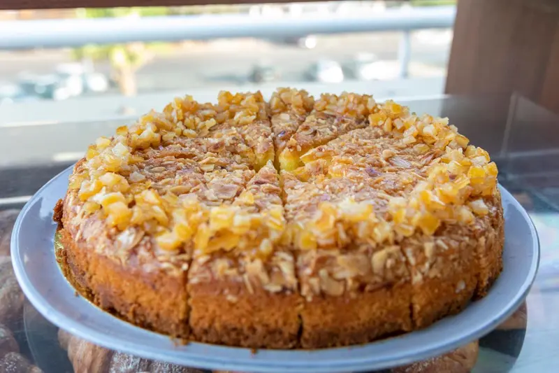 Un gâteau rond à l'ananas caramélisé est présenté sur une assiette.