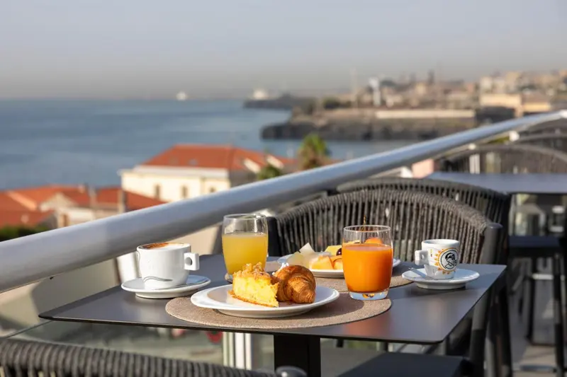 Une table est dressée avec un petit-déjeuner face à la mer.