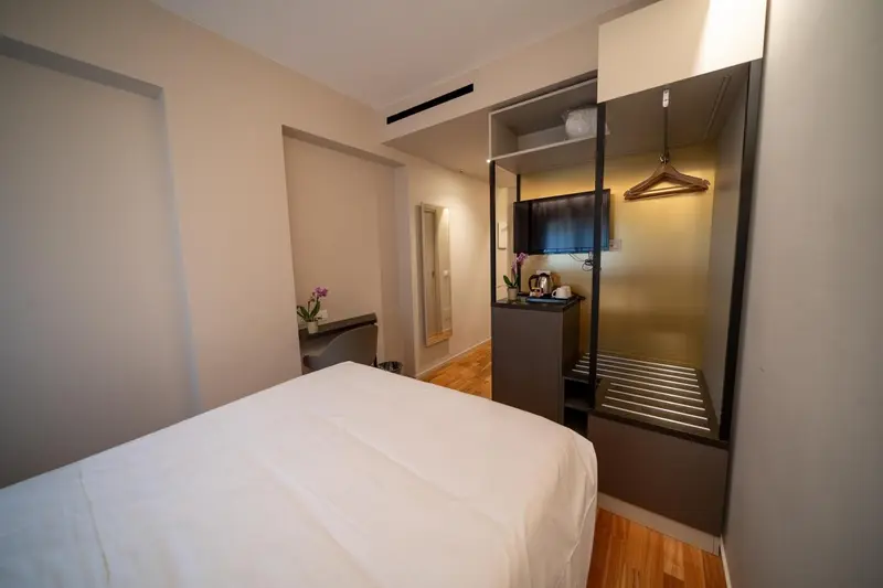 Une chambre lumineuse avec un lit blanc et un espace bureau.