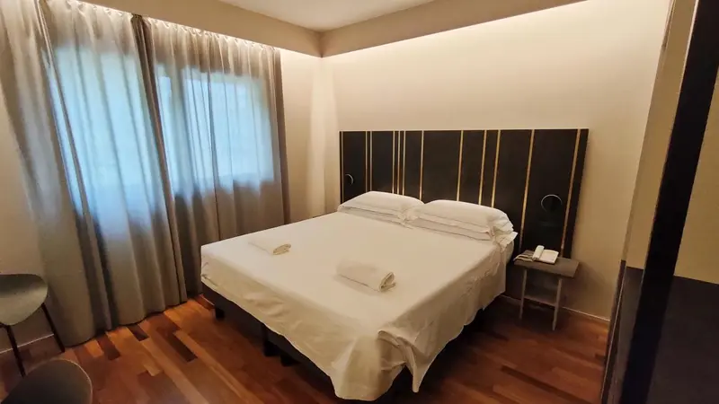 Une chambre lumineuse avec un grand lit recouvert de draps blancs.