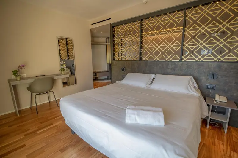 Une chambre lumineuse avec un grand lit et un bureau.