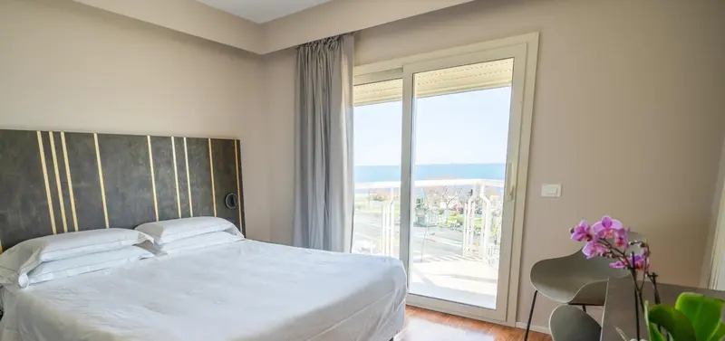 Une chambre lumineuse avec un grand lit et une vue sur la mer.