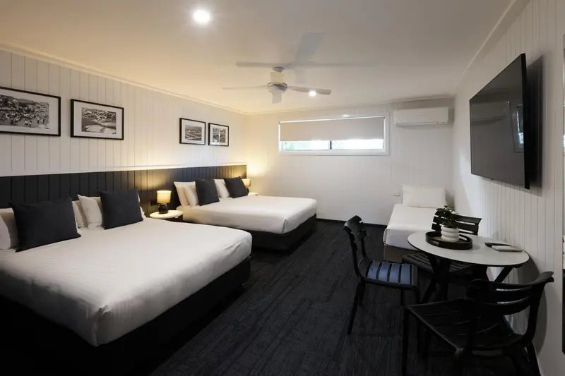 Une chambre lumineuse avec deux lits et un coin repas.