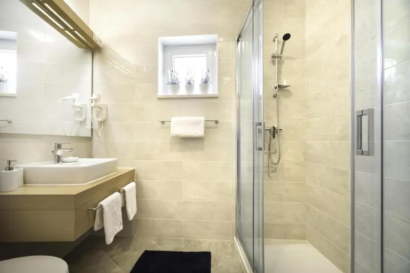 Une salle de bain claire avec douche à l'italienne et vasque.