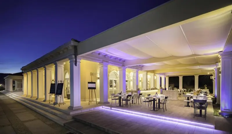 Terrasse lumineuse avec tables et chaises disposées pour un repas en extérieur.