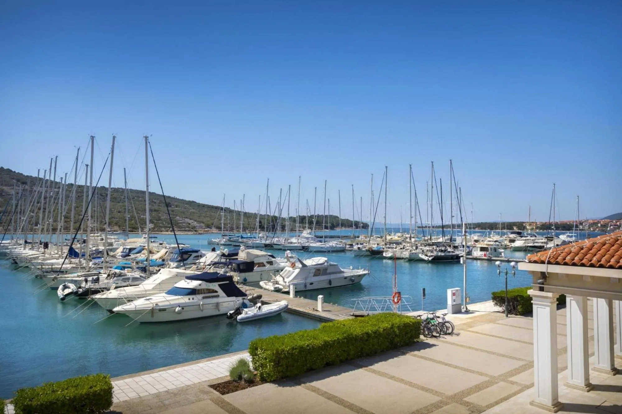 Port de plaisance ensoleillé avec de nombreux bateaux à quai.