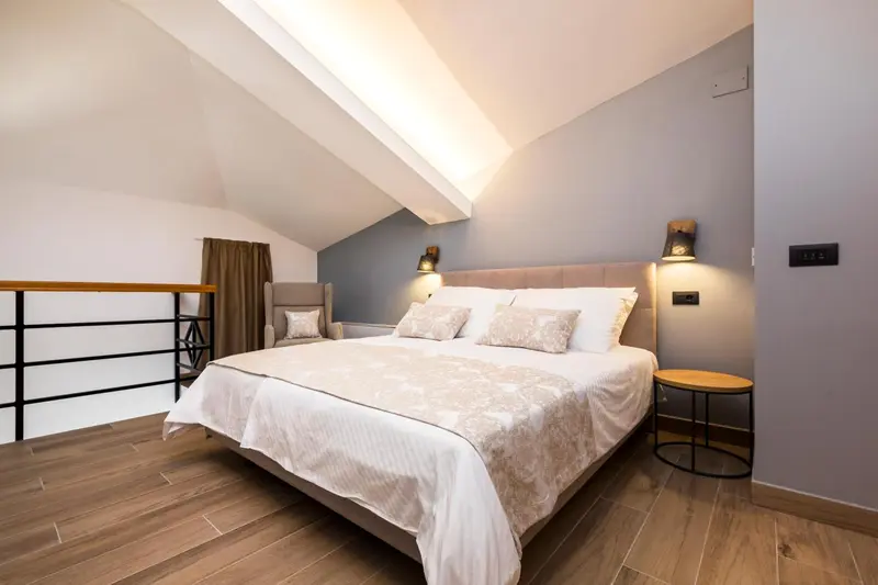 Une chambre lumineuse avec un grand lit et des oreillers décoratifs.