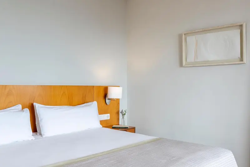 Une chambre lumineuse avec un grand lit et une décoration sobre.