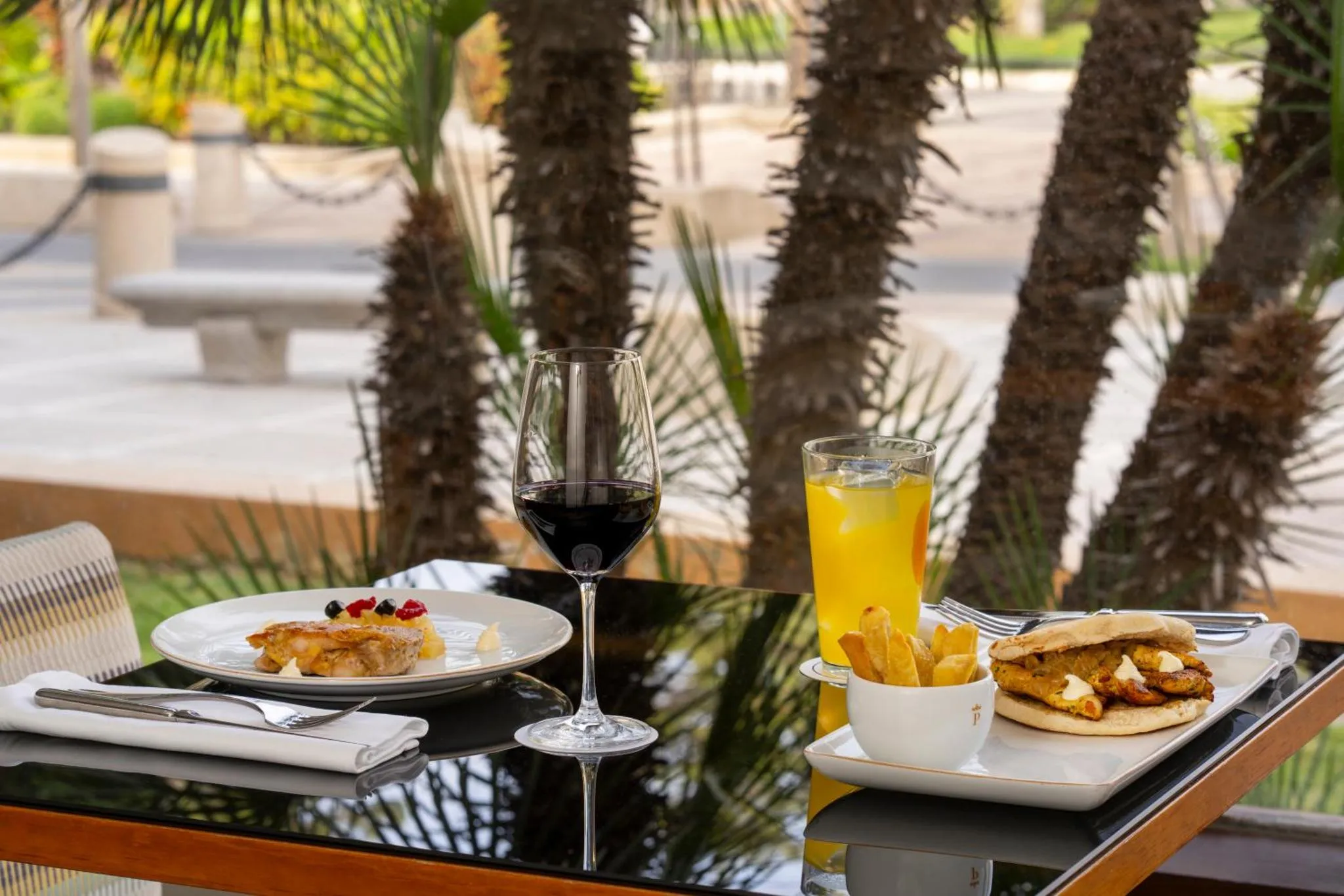 Une table est dressée avec des plats et des boissons sur une terrasse.