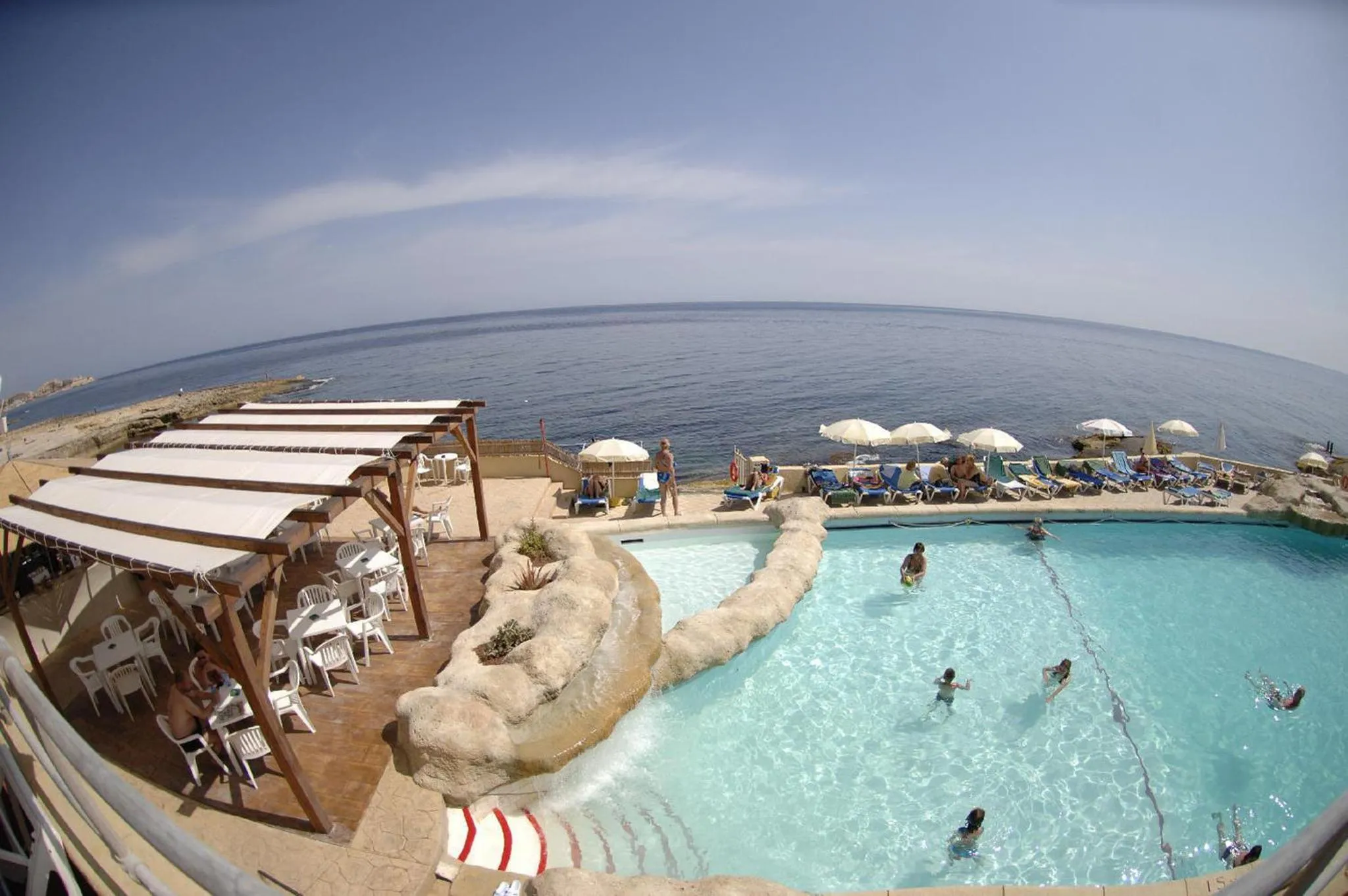 Terrasse avec piscine et vue sur la mer.