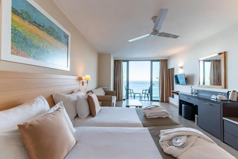Une chambre lumineuse avec un grand lit et un accès à une terrasse.